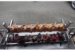 Acht Hähnchen auf einem Grill über Holzkohle