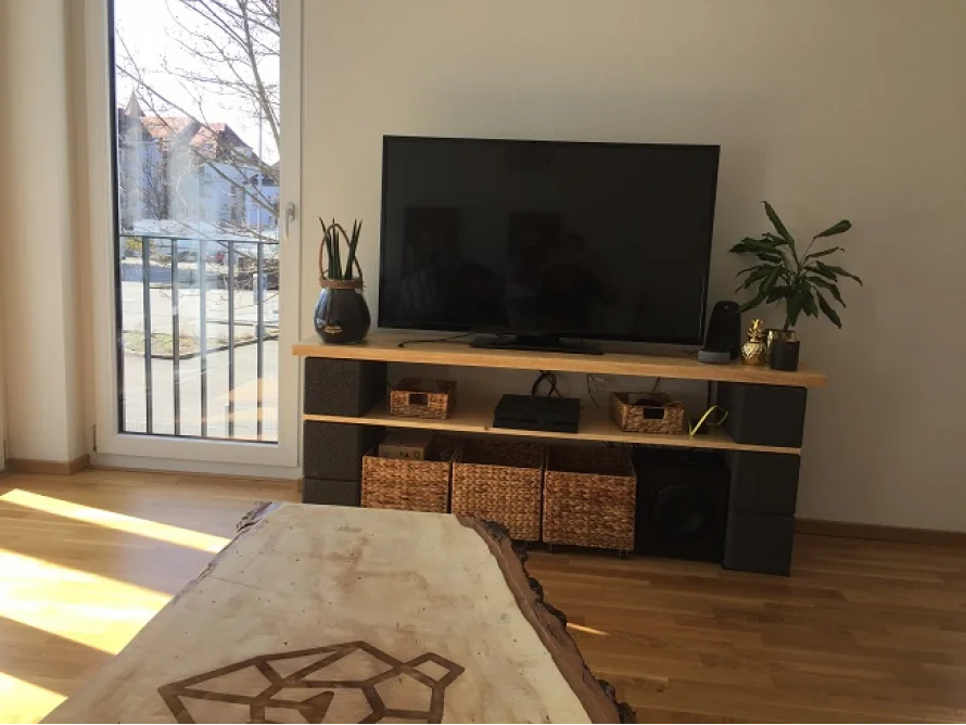 Ein Wohnzimmer mit einem Fernsehgerät und einem Couchtisch