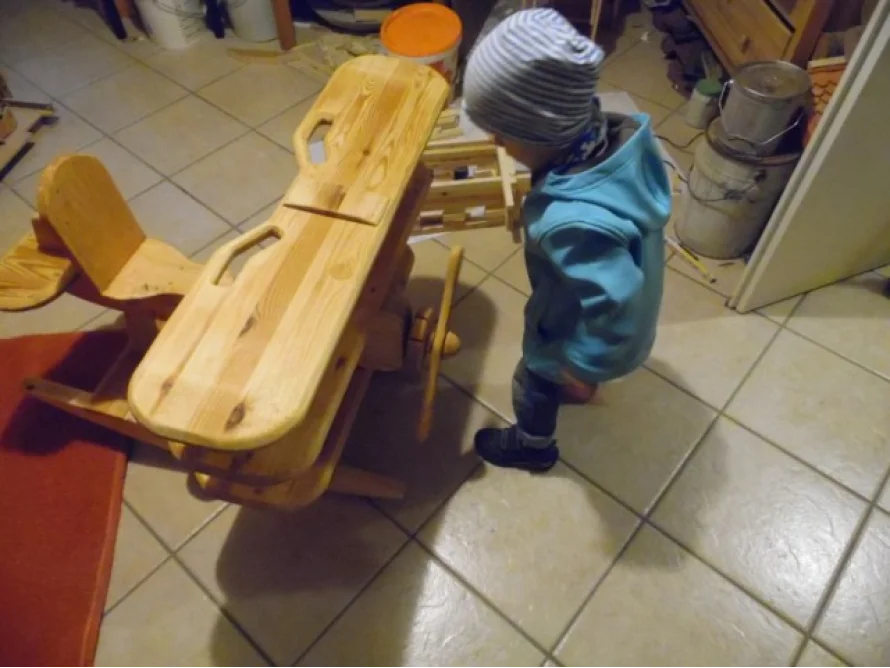 Kind bei einem Flugzeug aus Holz