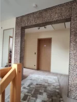 Flur mit Steinwand und Holztür
