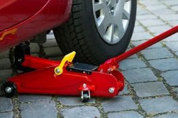 Ein Wagenheber hebt ein Auto an.