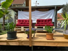 Gartenlounge aus Paletten mit roten Auflagen