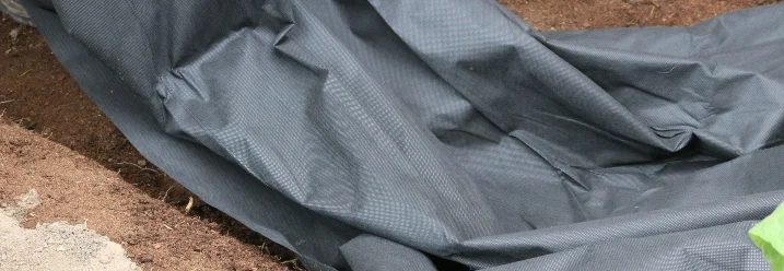 Schwarze Teichfolie auf Erde