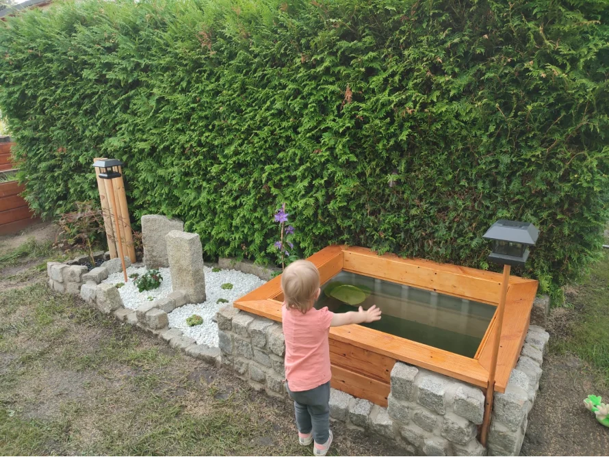 Kleinkind betrachtet einen kleinen Teich.