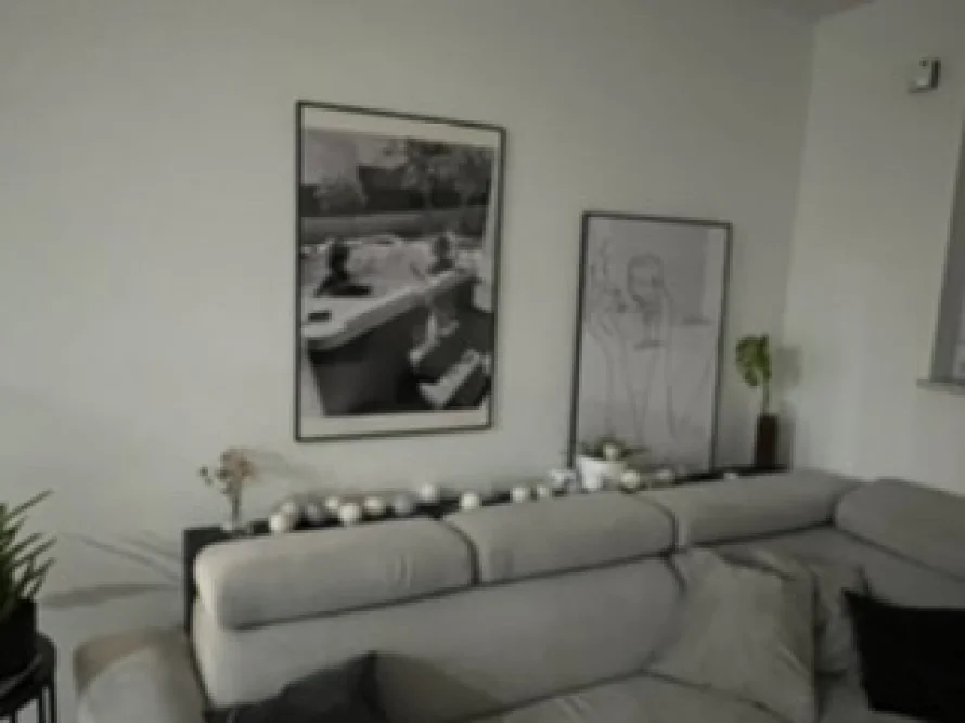 Ein Wohnzimmer mit einer Couch und zwei Bildern