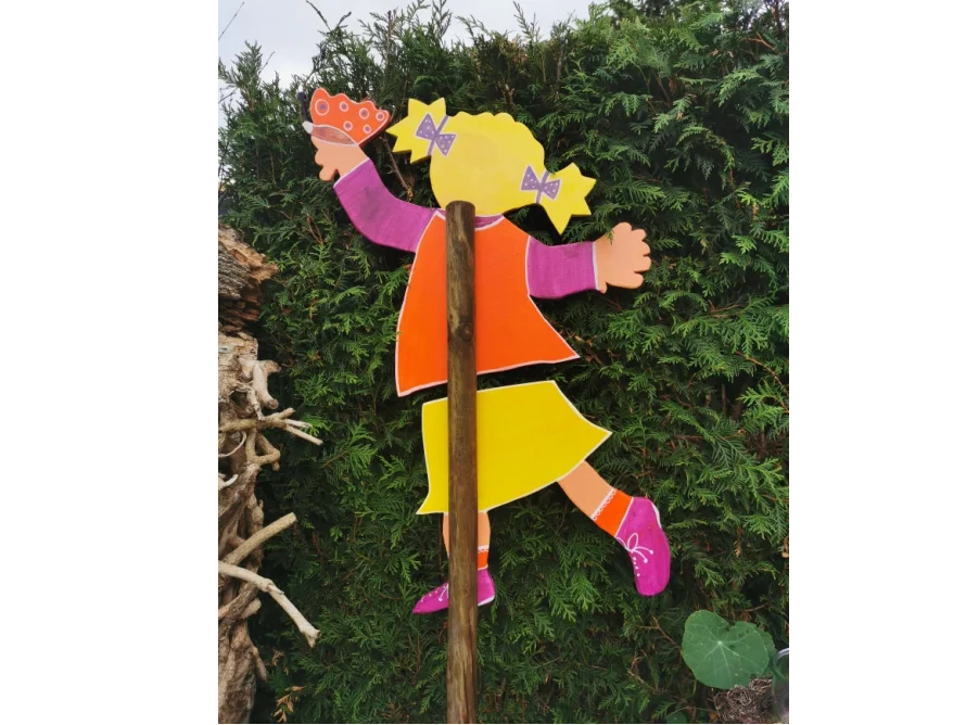 Holzfigur eines Kindes mit Schmetterling