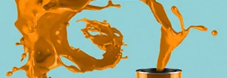 Orange Farbe spritzt aus Eimer