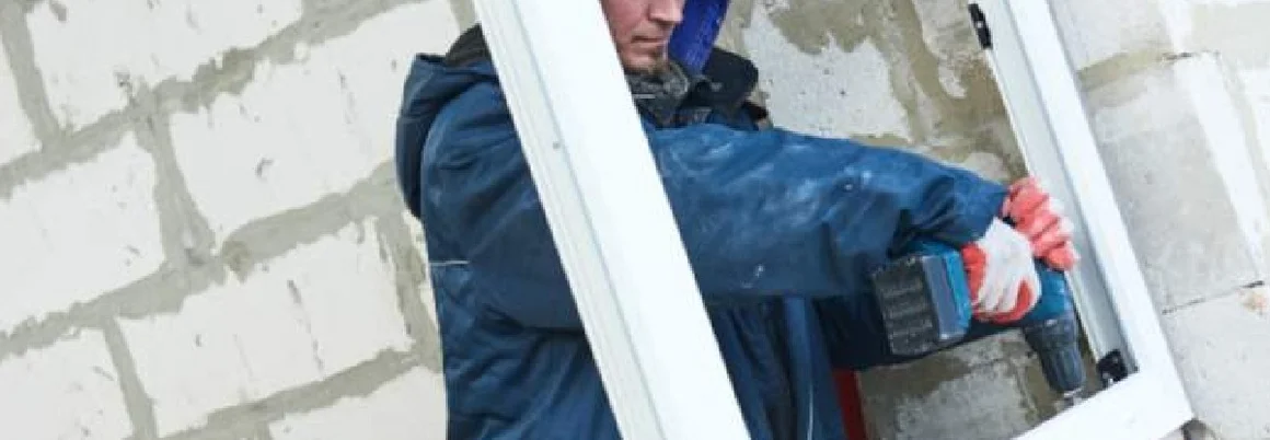 Person mit Helm und Bohrer bei der Arbeit