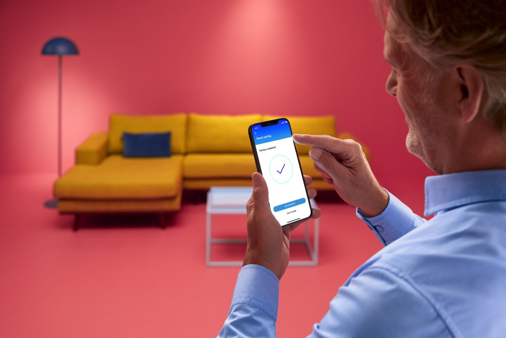 Person hält Smartphone mit Einrichtungsapp in der Hand